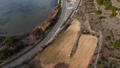 Aerial:-road-intersection-in-french-countryside-with-a-bike-and-very-little-traffic-during-winter