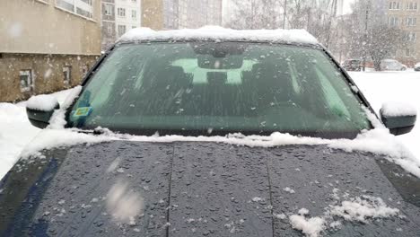 Snow-mist-moisture-on-bonnet-of-sedan-car-during-snowfall