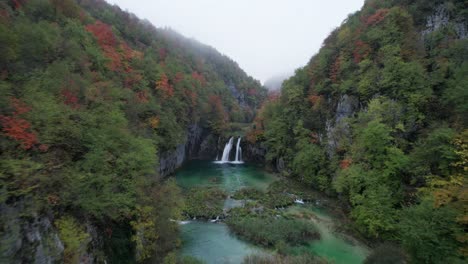 Aerial-through-fairytale-Plitvice-valley-during-cloudy-morning,-Croatia
