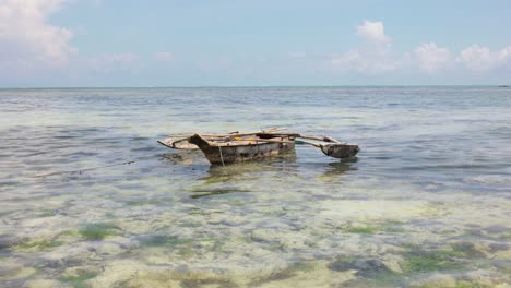 Lonesome-fishing-boat-off-the-coast-of-Paje,-Zanzibar,-Tanzania,-wide-shot
