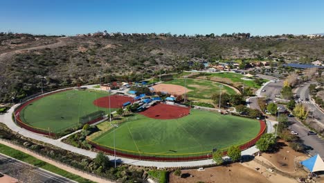 Drone-rotating-right-to-left-to-capture-football-and-baseball-field-in-Alga-Norte-Park,-Carlsbad,-California