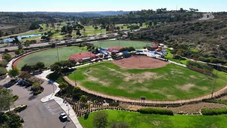 Drone-moving-forward-towards-a-baseball-field-inside-Alga-Norte-Park,-Carlsbad,-California