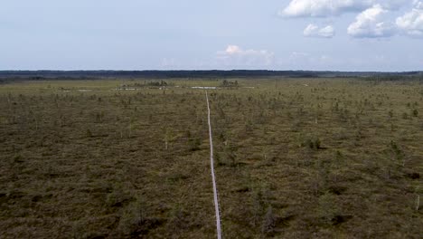 Moving-along-a-wooden-pathway-in-Nigula-bog,-Estonia