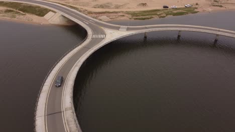 A-drone-follows-a-car-on-a-circular-bridge-at-Laguna-Garzon