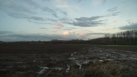 Cultivated-arable-soil-in-evening-time,-cloudscape-time-lapse-shot
