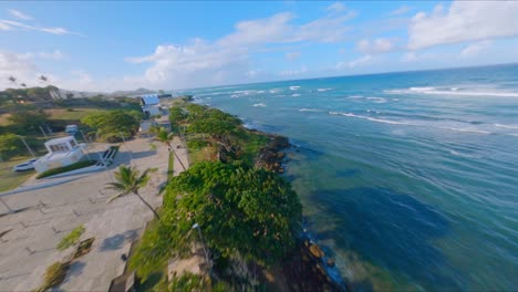 Drone-Flying-From-Parque-Juan-Lockward-Towards-La-Puntilla-Park-Along-The-Edge-Of-The-Atlantic-Ocean-In-Puerto-Plata,-Dominican-Republic