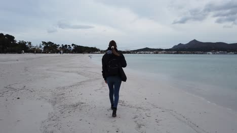 Mujer-Caminando-Por-Una-Playa-Solitaria-En-Invierno