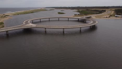 Allradfahren-Auf-Kreisförmiger-Brücke-In-Laguna-Garzon-Mit-Zwei-Kitesurfern-Im-Hintergrund,-Uruguay
