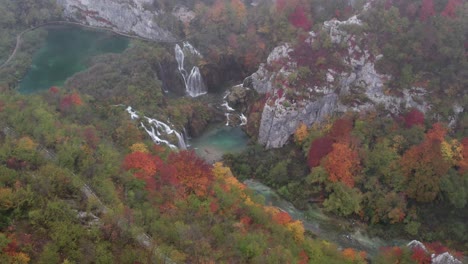 Plitvice-tourist-destination-with-waterfalls-covered-in-mist,-aerial