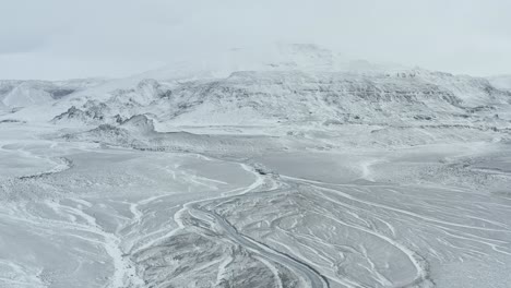 Siga-La-Corriente-Del-Río-Congelado-Cerca-Del-Glaciar-Langjokull-Islandia-Drone-Aéreo