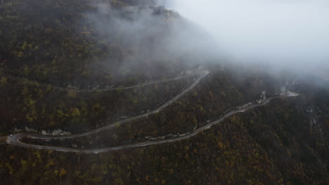 Aerial-View-of-the-mountain-serpentine-road-in-Kotor,-Montenegro-on-a-foggy-day