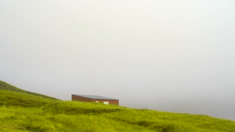 Pintoresca-Cabaña-Roja-Solitaria,-Exuberante-Campo-Verde-En-Las-Tierras-Altas-De-Islandia