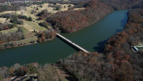 Aerial-View-of-Bridge-Above-Curvy-Lake-in-Warriors-State-Park,-Tennessee-USA-on-Sunny-Fall-Day,-Drone-Shot