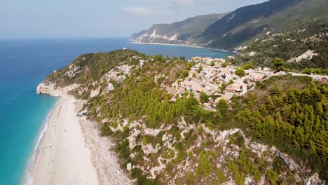 Playa-De-Kathisma,-Isla-De-Lefkada,-Grecia---Drone-Aéreo-Ve-La-Costa-Con-Playa-De-Arena-Y-Hoteles-Con-Piscinas