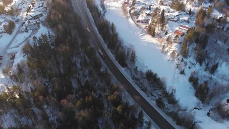 Camiones-Conduciendo-En-Carreteras-Frías-Con-Nieve-Durante-El-Invierno---Toma-Aérea-De-Drones
