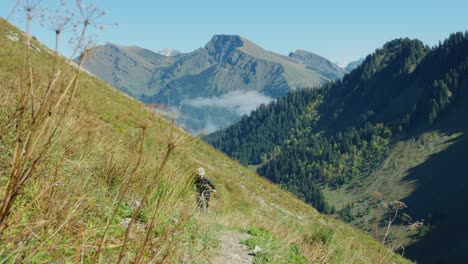 A-mountain-biker-is-pedalling-up-an-alpine-trail-in-autuumn