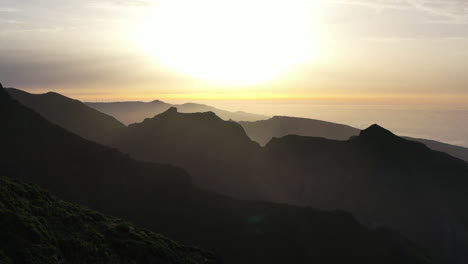 Golden-Hour-Sunlight-Above-Atlantic-Ocean-and-Silhouettes-of-Hills,-Aerial-View-of-Madeira-Island-Landscape,-Portugal