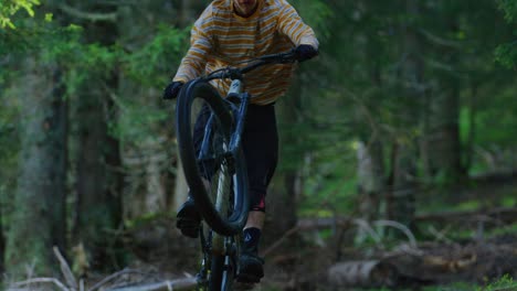 A-mountain-biker-rides-on-his-rear-wheel-only