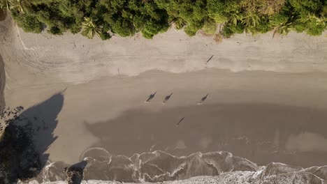Aerial-view-of-people-walking-on-Manuel-Antonio-beach-in-Quepos,-Costa-Rica-bird-eye-wide-shot