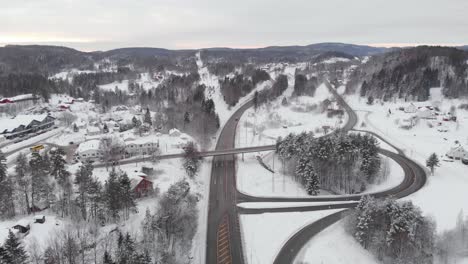 Aerial-view-of-snow-covered-fields-with-roads-among-trees---drone-static