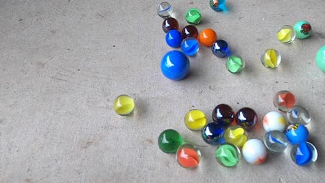 Lots-of-bright-rolling-marbles-collide-on-a-concrete-floor-in-slow-motion