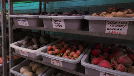 Organic-Root-Vegetables-in-Grocery-Market-sitting-on-Industrial-Metal-Shelf-with-Hand-Written-Price-Tags