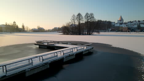 Snowy-Bridge-At-Frozen-Pottery-Pond-At-Sunrise-In-Community-of-Gorowo-Ilaweckie,-Poland