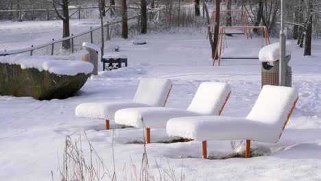 Una-Gruesa-Capa-De-Nieve-Que-Cubre-Los-Sillones-Inactivos-De-Un-Parque-Público-En-Suecia