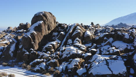 Aerial-of-Alabama-Hills-snow-covered-rounded-rock-formations-in-winter