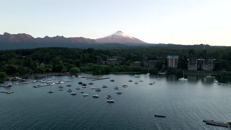 Aerial-view-of-the-villarrica-volcano-in-pucon-with-boats-parked-on-the-lake---drone-shot