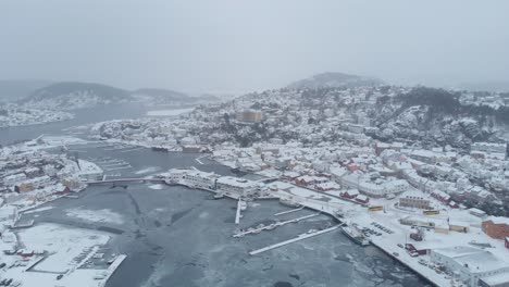 Vista-Aérea-Del-Fiordo-Congelado,-Ciudad-De-Kragerø-Cubierta-De-Nieve-En-Un-Invierno-Brumoso-En-Noruega