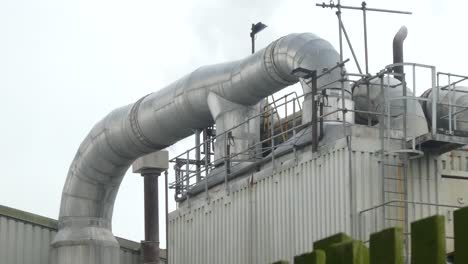 Industrial-warehouse-insulation-pipes-steaming-on-roof-cooling-system-vent-pipeline