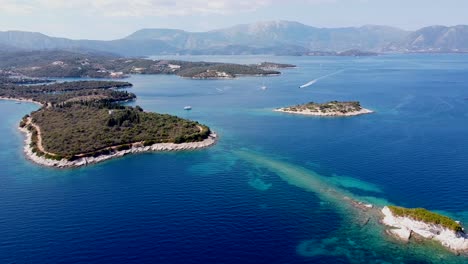 Isla-Meganisi,-Lefkas,-Grecia---Vista-Aérea-De-Drones-De-Barcos,-Jetski,-Montañas-Y-Mar-Azul