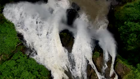 Dramatic-stony-waterfall,-green-nature-in-Indonesia,-overhead-aerial