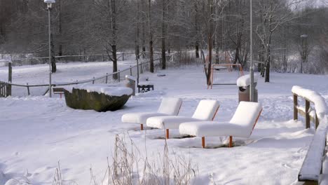 Öffentliche-Liegestühle-Im-Verlassenen-Stadtpark-Im-Winter,-Schweden