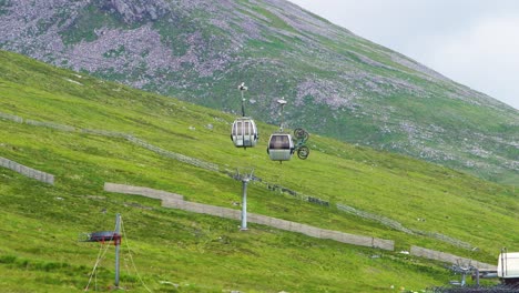 Stationary-cable-car-trays-with-two-mountain-bikes-on-the-outside-of-the-cabin-waiting-for-the-cable-car-to-start-running-again-after-a-malfunction-in-Scotland
