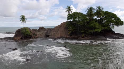 Aerial-truck-left-of-rugged-rocky-coast-and-foamy-sea-waves-on-a-cloudy-day-in-Dominicalito-Beach,-Costa-Rica
