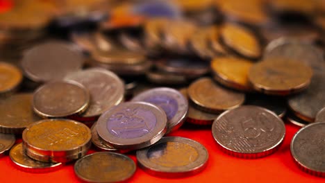 Nahaufnahme-Rotierender-Schuss-Der-Anzahl-Der-Euro-Münzen-Geld-Auf-Rotem-Hintergrund,-Nahaufnahme