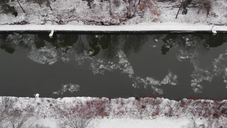 Top-down-view-winter-Landscape-along-snow-covered-Trollhätte-Canal,-Sweden