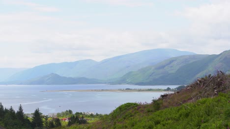 View-over-Ardgour-Beach-in-Loch-Linnhe-amongst-the-hilly-landscape-of-Scotland-on-a-cloudy-windless-day