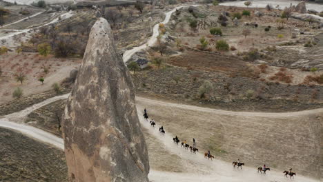 Caravan-Of-Horses-In-Scenic-Cappadocia-Landscapes-In-Turkey---aerial-drone-shot