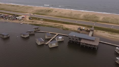 A-drone-orbits-floating-homes-in-Laguna-Garzon,-Uruguay
