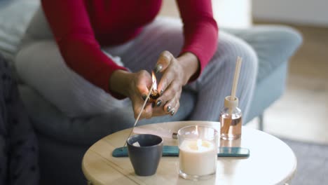 Aromatherapy-table-setting-with-perfumed-candles,-oil-burner-and-mood-reeds-in-natural-window-light,-dolly-slider-shot,-shallow-DOF