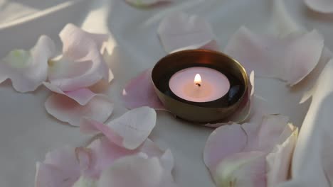 Cinematic-shot-of-spa-items---orchid-flowers-with-burning-candles-and-white-towel