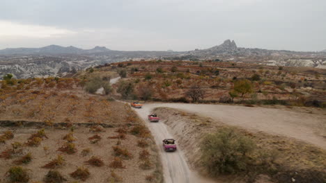 Three-Classic-Convertible-Cars-Driving-Through-Dirt-Track-In-Cappadocia,-Turkey