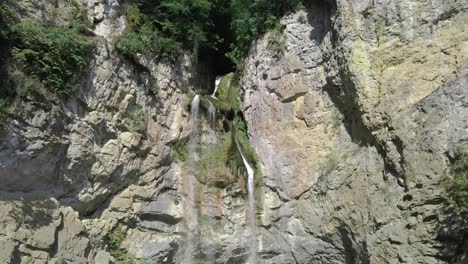 Drohne-Zoomt-Aus-Natürlichem-Wasserfall-In-Felsiger-Bergklippe-Heraus