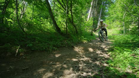 A-mountain-biker-rides-down-a-trail-at-high-speed