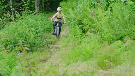 A-mountain-biker-rides-down-a-trail-on-a-warm-day-in-slow-motion