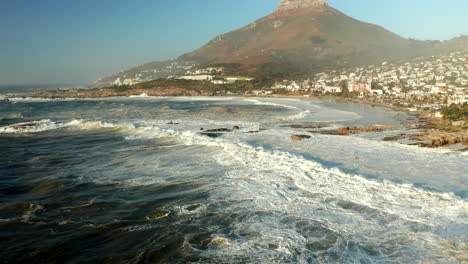 Foamy-Ocean-Waves-Coming-Into-The-Shoreline-Of-Camps-Bay-And-Bakoven-Beaches-In-Cape-Town,-South-Africa