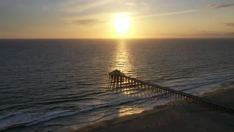 Sunset-Reflecting-In-The-Ocean-Towards-The-Manhattan-Beach-Pier-In-California,-USA
